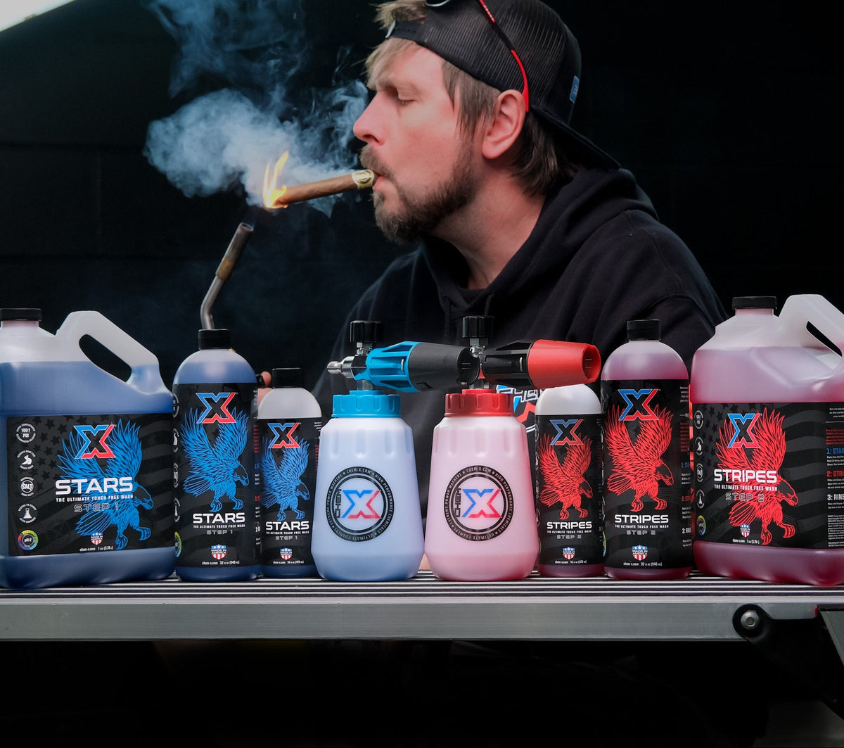 Bob smoking a cigar above a line-up of Stars + Stripes bottles and foam cannon