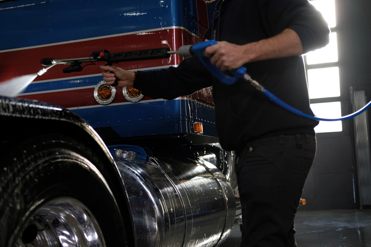 Chem-X Freedom Foamer lance rinsing off blue and red truck.