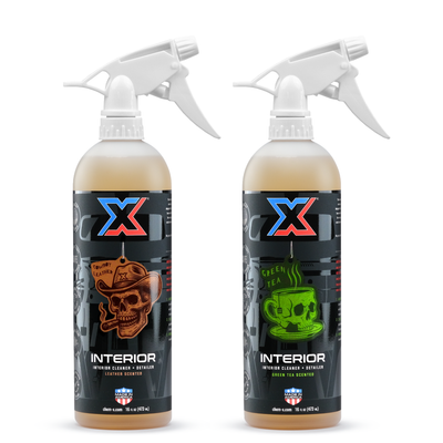 A 16oz bottle of orange leather-scented interior cleaner + detailer with a white tolco trigger sprayer called Interior next to a 16oz bottle of orange green tea-scented interior cleaner + detailer called Interior on a white background.