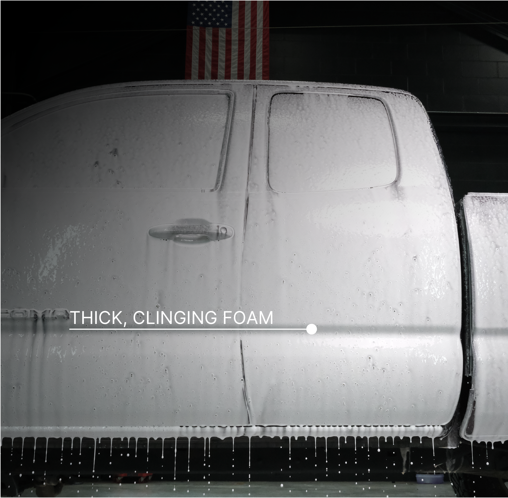 A close-up of a truck door covered in dripping foam, with the text 'THICK, CLINGING FOAM' overlaid across the lower middle. An American flag is faintly visible in the dark background above the truck.