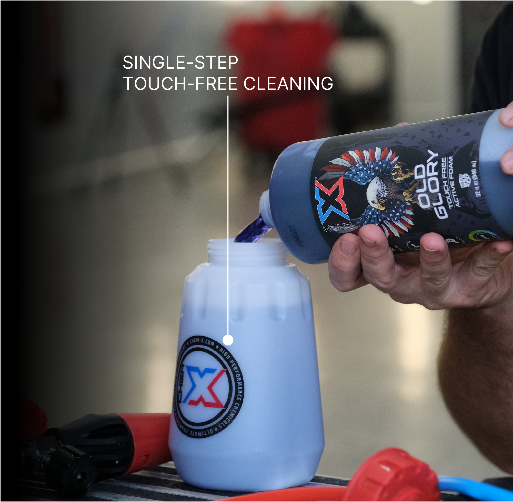 A person holds a bottle of Chem-X Old Glory over a white bottle, demonstrating single-step touch-free cleaning with the text 'SINGLE-STEP TOUCH-FREE CLEANING' across the top of the image. The Chem-X Old Glory bottle has a black label with red, white, and blue graphics, and the white bottle has a circular Chem-X logo on the front.