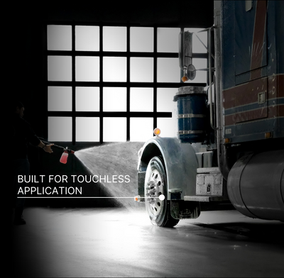 A truck in a garage being sprayed with foam from a foam cannon attachment, with a person visible on the left. Text on the image reads 'BUILT FOR TOUCHLESS APPLICATION.'